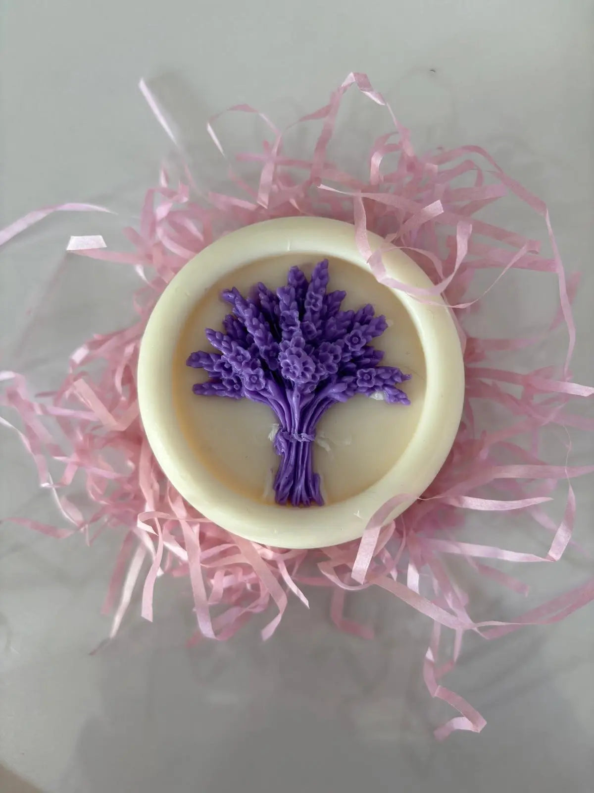 Soap with lavender design on a bed of pink shredded paper